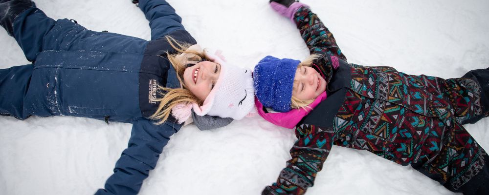 Smiling Children making snow angels at The Highlands